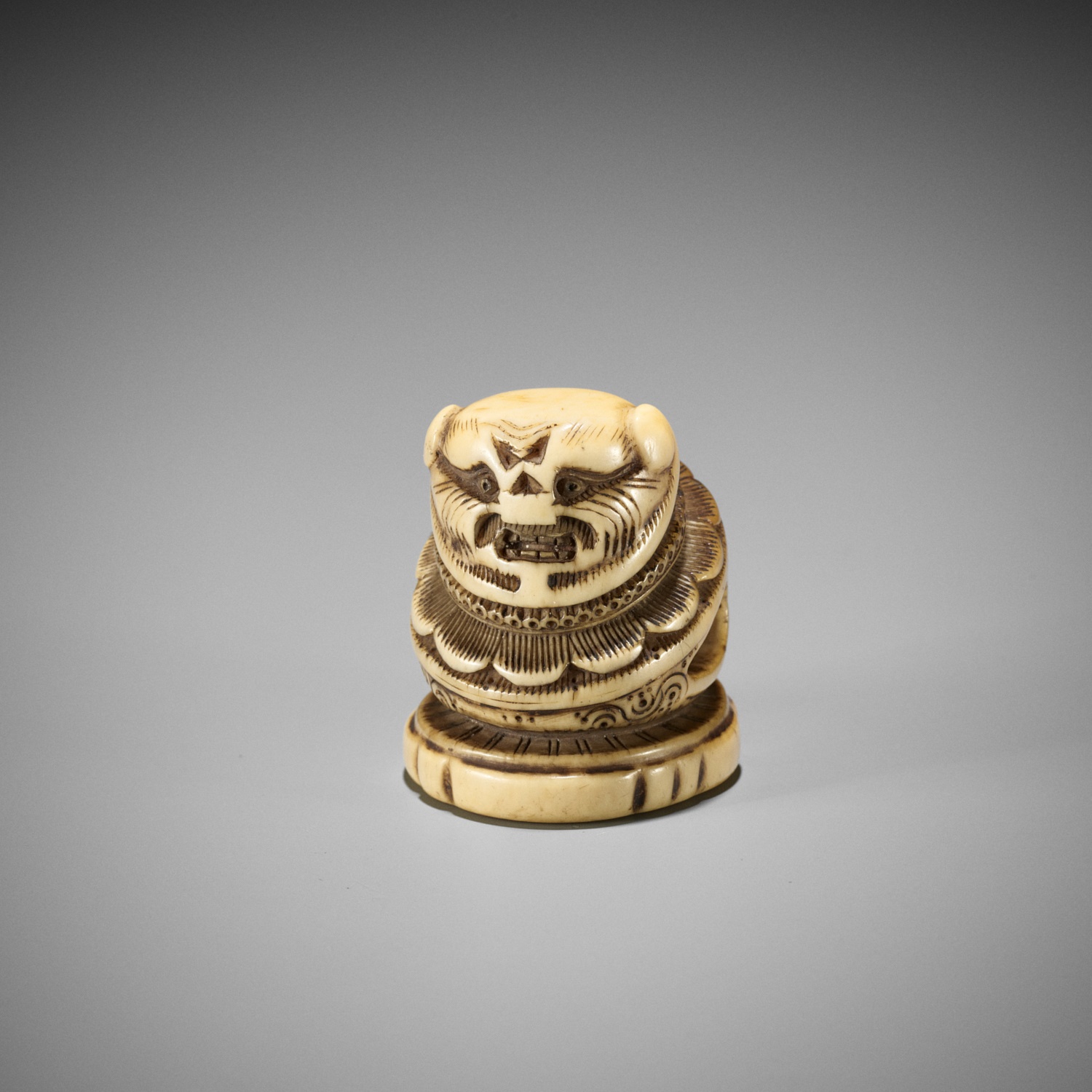 A RARE IVORY 'SILK SEAL' TYPE NETSUKE OF A FOREIGNER