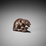 A FINE WOOD NETSUKE OF A WOLF WITH HAUNCH OF VENISON