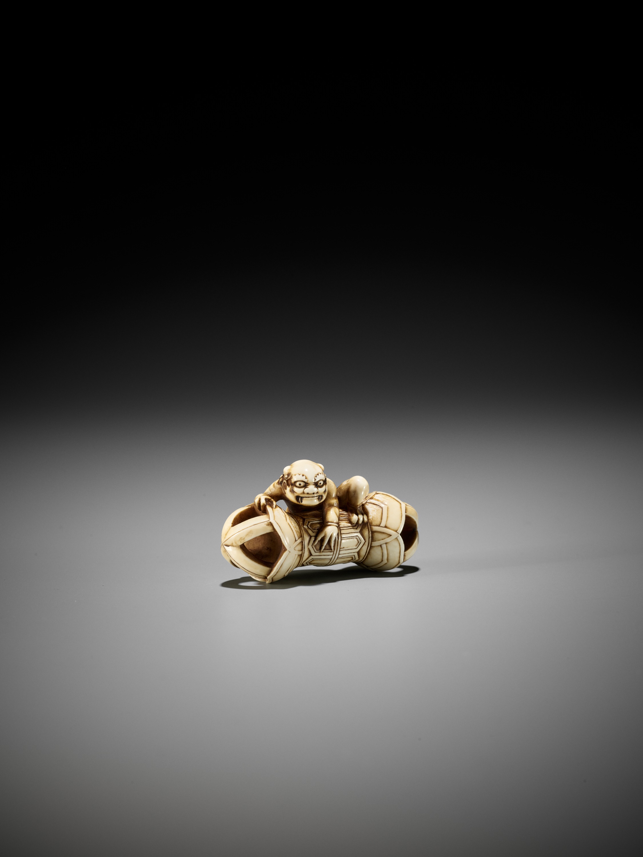 A RARE IVORY NETSUKE OF AN ONI ON A KONGO (VAJRA) - Image 3 of 12