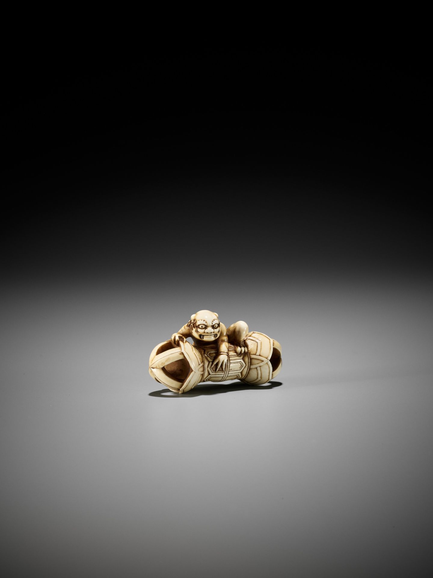 A RARE IVORY NETSUKE OF AN ONI ON A KONGO (VAJRA) - Image 3 of 12