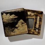 A BLACK AND GOLD LACQUER SUZURIBAKO WITH A SHORELINE LANDSCAPE AND RED-CRESTED CRANES