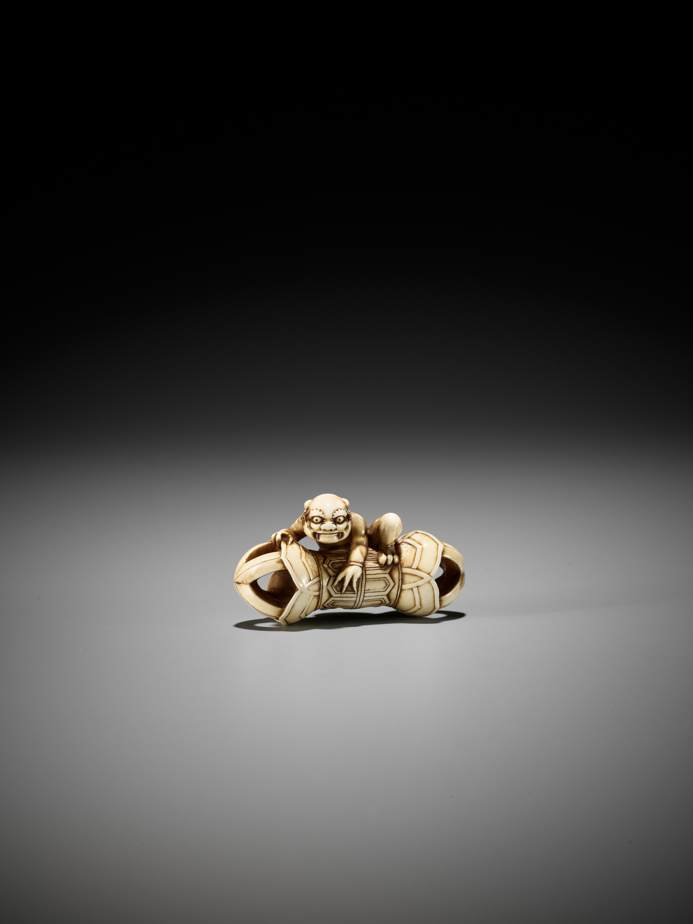 A RARE IVORY NETSUKE OF AN ONI ON A KONGO (VAJRA) - Image 4 of 12