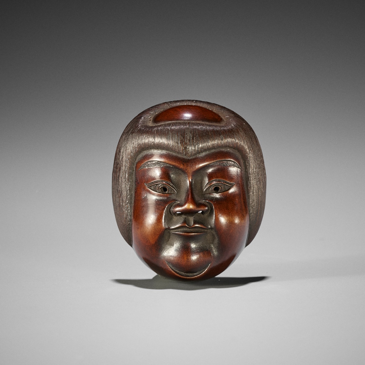 SHUZAN: A VERY FINE WOOD MASK NETSUKE OF KINTARO