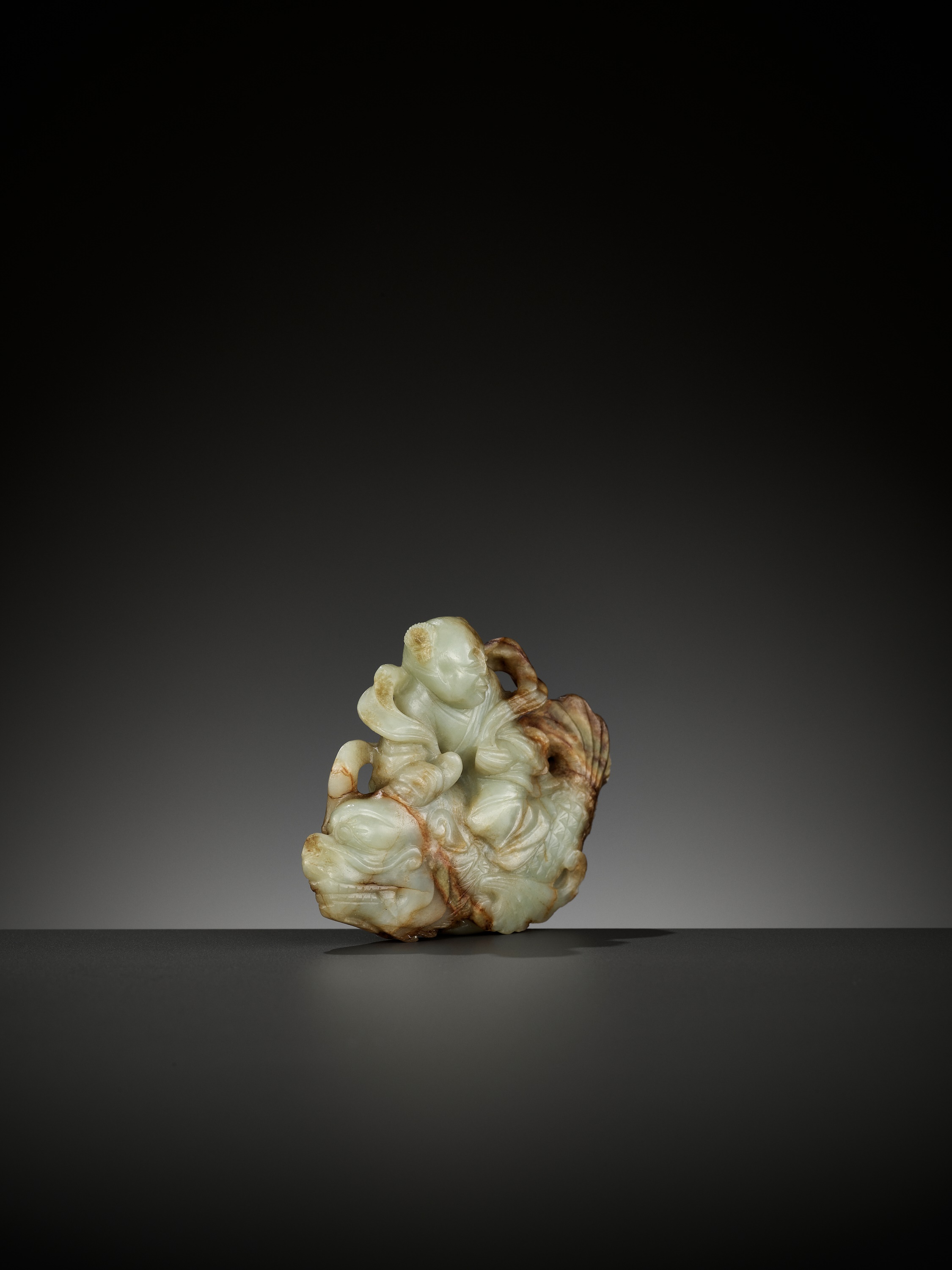 A CELADON AND RUSSET JADE FIGURE OF A BOY RIDING A DRAGON-CARP, 17TH-18TH CENTURY - Image 9 of 13