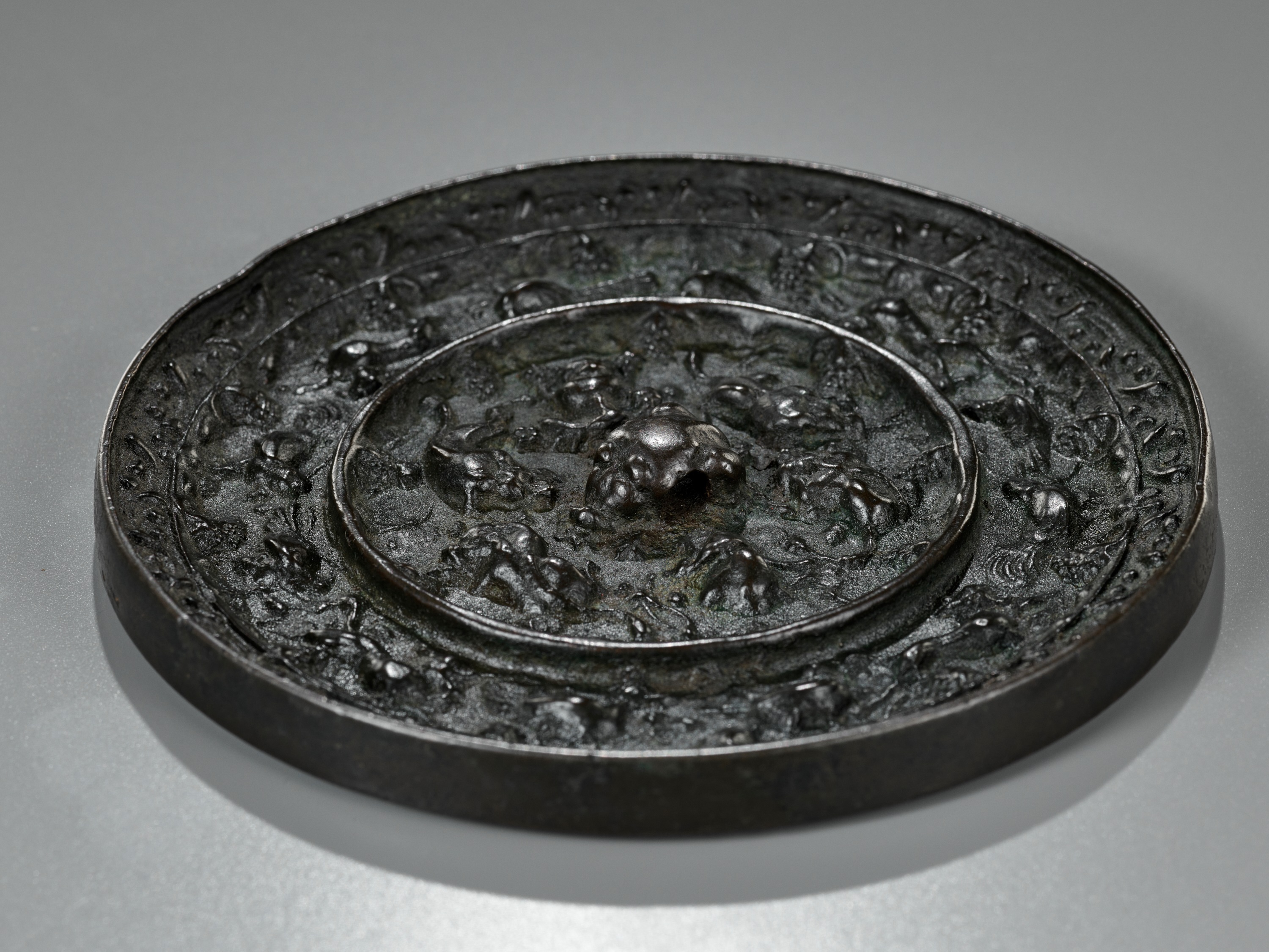 A BRONZE 'XINIU' MIRROR STAND AND 'LION AND GRAPEVINE' MIRROR, MING AND TANG DYNASTY - Image 19 of 20