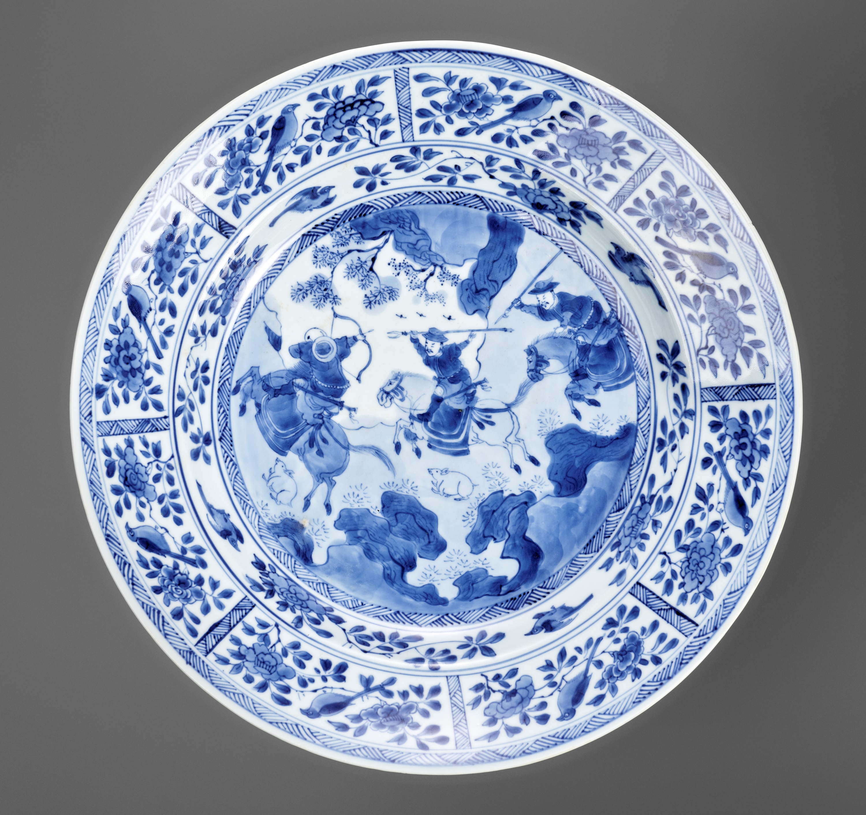 A LARGE BLUE AND WHITE 'HUNTING SCENE' DISH, KANGXI PERIOD