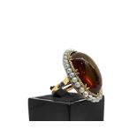 Ring with amber oval surrounded by beads