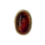 Brooch with oval in amber and surrounded by beads