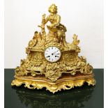 Gold metal clock in display case, nineteenth century