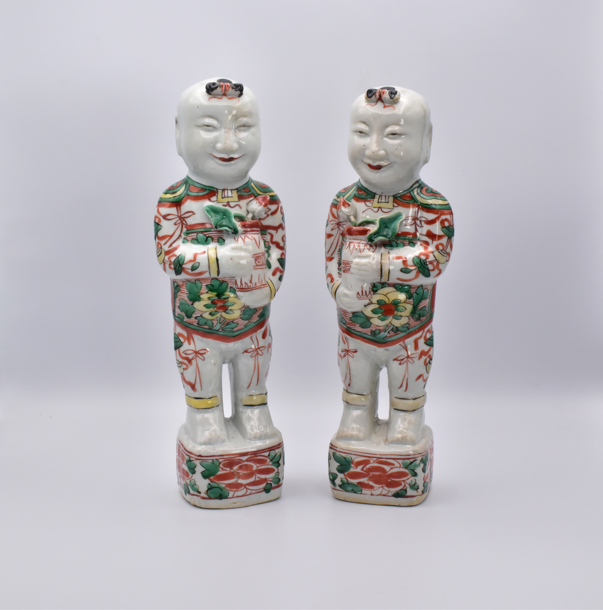 A PAIR OF CHINESE ‘LAUGHING BOYS’ PORCELAIN FIGURES, QING DYNASTY, KANGXI PERIOD, 1662 – 1722