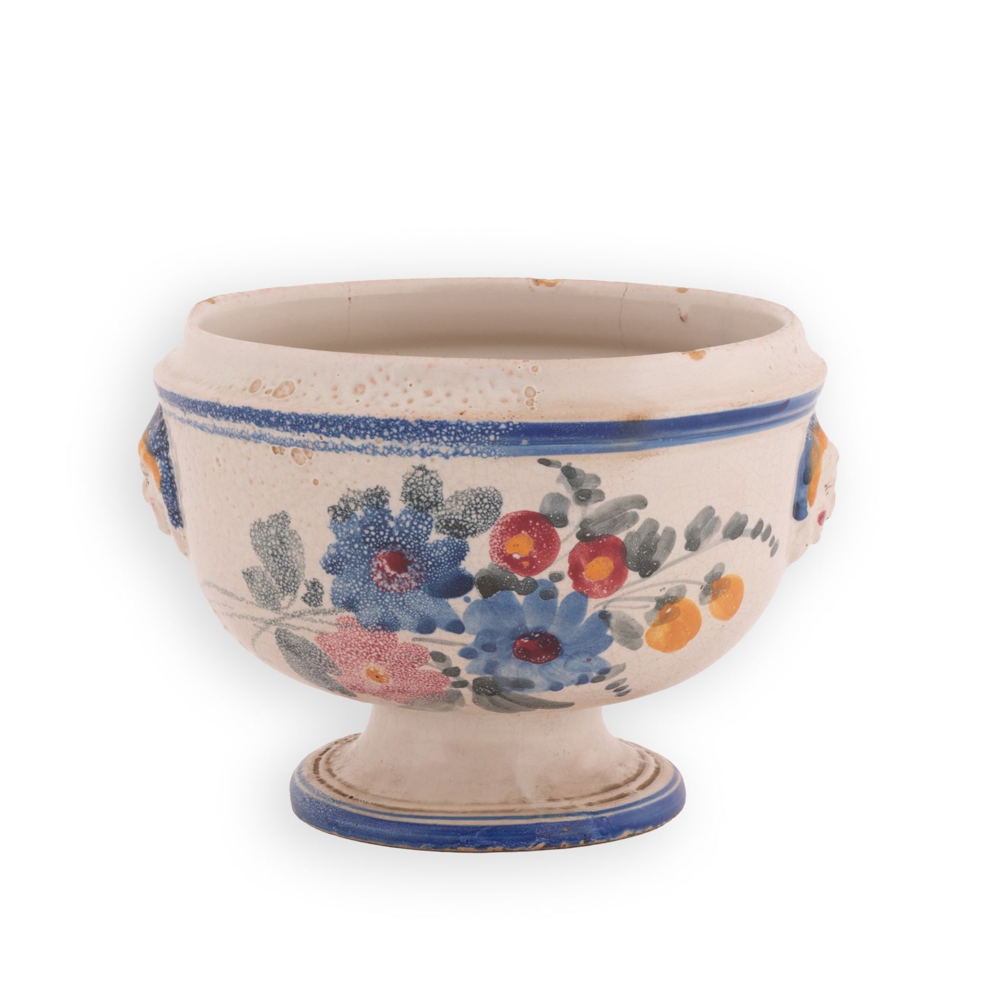 Zuppiera in maiolica decorata in policromia con motivi floreali e bordatore in blu. Ai lati maschero