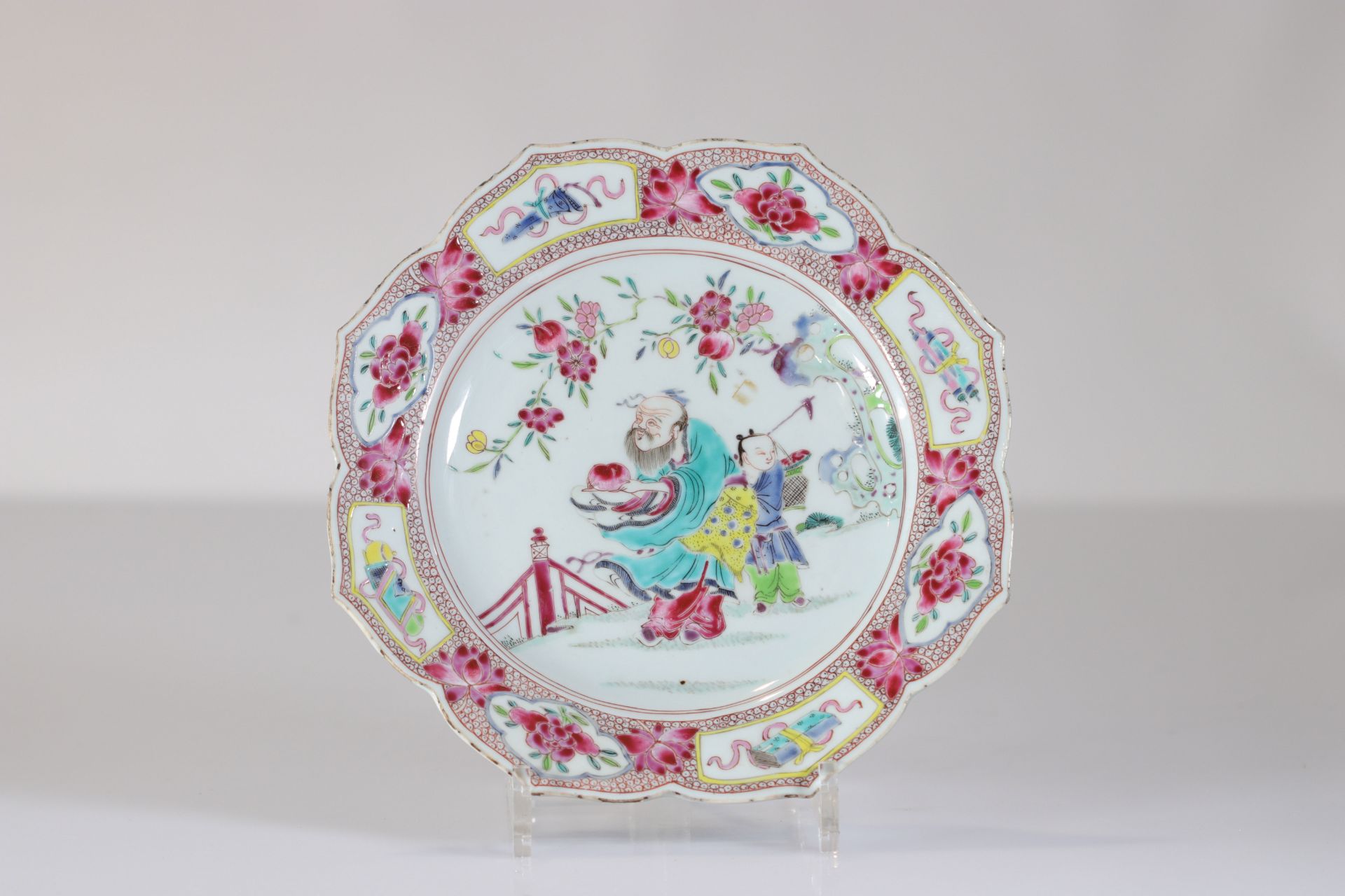 Porcelain plate from the 18th century famille rose beautiful decoration of a character holding the