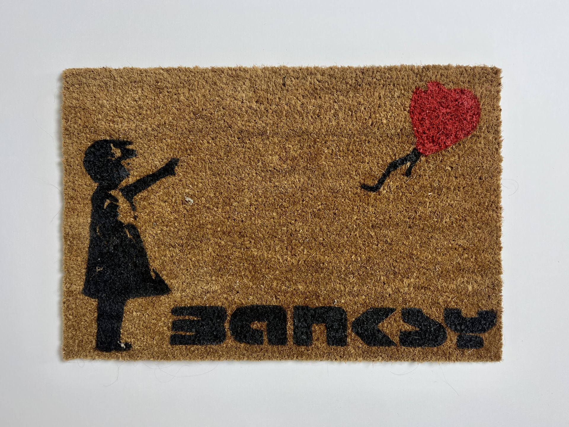 Banksy. â€œGirl with balloonâ€. Stencil painted doormat.