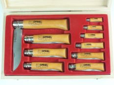 A cased set of ten non-locking folding Opinel pocket knives, graduated sizes, the largest with a