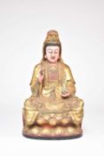 A large Chinese lacquered and parcel gilt carved wood figure of Guanyin