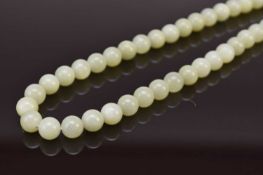 A pale green jade bead necklace, 20th century