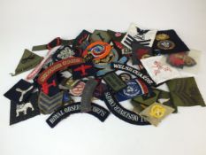 A collection of approximately 86 military cloth badges, including WW2.