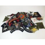 A collection of approximately 86 military cloth badges, including WW2.