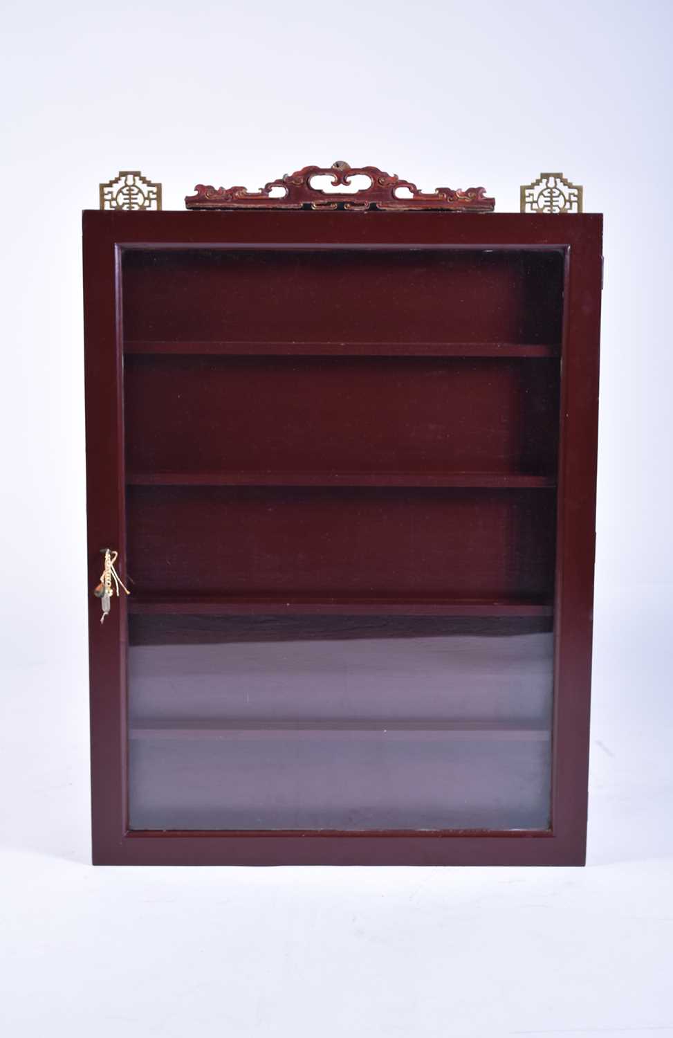 A Chinese rosewood effect wall-hanging glazed curio cabinet