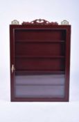 A Chinese rosewood effect wall-hanging glazed curio cabinet
