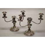 A pair of early 20th silver plated two branch three sconce table candlesticks, each cast with
