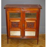 An Edwardian walnut side cabinet, the rectangular top over a pair of florally carved and mirror