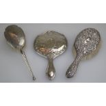 A George V silver backed brush with floral repousse decoration, Birmingham 1924, another later brush