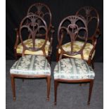 A pair of Edwardian mahogany parlour armchairs having spoon back, leaf carved pierced scrolled