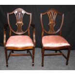 A set of twelve reproduction mahogany dining chairs each having shield back, pierced waisted tied