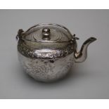 An early 20th century Chinese white metal bun form teapot and cover with twin wire handles, the body