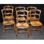 A set of six late 19th century French oak ladder back dining chairs, each having leaf and scallop