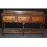 A 19th century oak dresser base, the oblong base with a shallow rear ledge over three frieze drawers