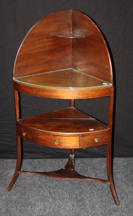 An early 19th century mahogany corner washstand, the shelved superstructure over two tiers, the