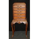 A reproduction burr walnut veneer chest on stand of small proportions, the caddy top over egg and