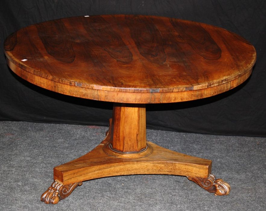 A late Regency rosewood breakfast table, the circular tilt top on an octagonal column, concave