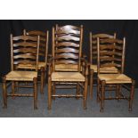 A set of six reproduction elm ladder back dining chairs, each with woven rush seat, on turned