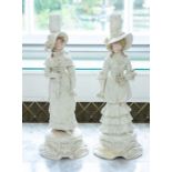 A pair of late 19th century European ceramic candlesticks, in the form of two women with flowers,