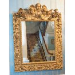 A large and impressive 19th century giltwood rococo style mirror with foliate scrollwork surrounding