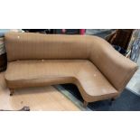 A reproduction Victorian style corner sofa, on plastic casters with brown ground upholstery