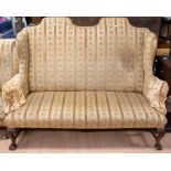 An early 20th Century two-seater sofa in with oak frame and legs and gold upholstery