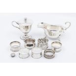 A group of silver to include: posset cup and cover; sauce boat, four various napkin rings, salt,