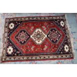 A hand-knotted woollen rug with geometric patterns on a mainly blue ground, 160 x 110cm