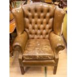 A mid to late 20th Century, brown leather Chesterfield wingback single armchair