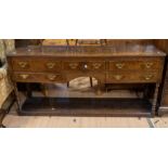 A George III oak dresser base having shelved base, five drawers three above two, on turned supports,