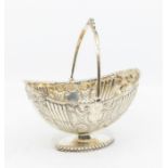 A late Victorian silver boat shaped sugar basket, chased fluted, floral and geometric decoration,