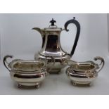 An Edwardian silver three piece coffee service of rounded baluster form on ball feet, comprising