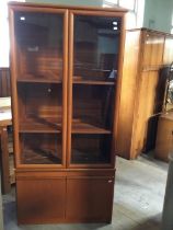 A contemporary teak veneered display cabinet over cupboard in two pieces to be be placed on top of