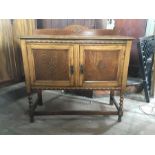 A 20th century oak and oak veneer small sideboard/unit, carved frieze, panels to front of both