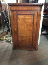 A late 18th century oak corner cabinet, dentil moulding to upper cornice, various cuts of the wood