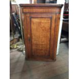 A late 18th century oak corner cabinet, dentil moulding to upper cornice, various cuts of the wood